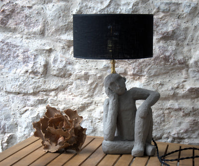 Lampe à poser Le Penseur, sculpture figurative béton, abat-jour lin noir.