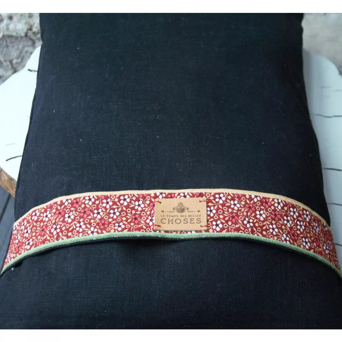 Coussin décoratif lin noir et bandes de passementerie en velours.