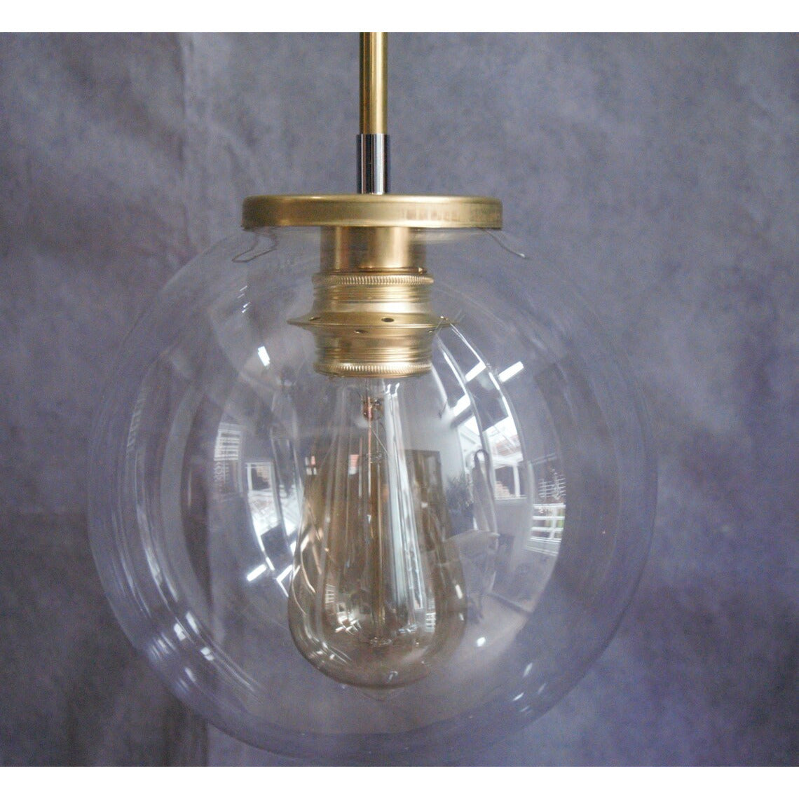 Suspension minimaliste tube en laiton et globe en verre transparent.