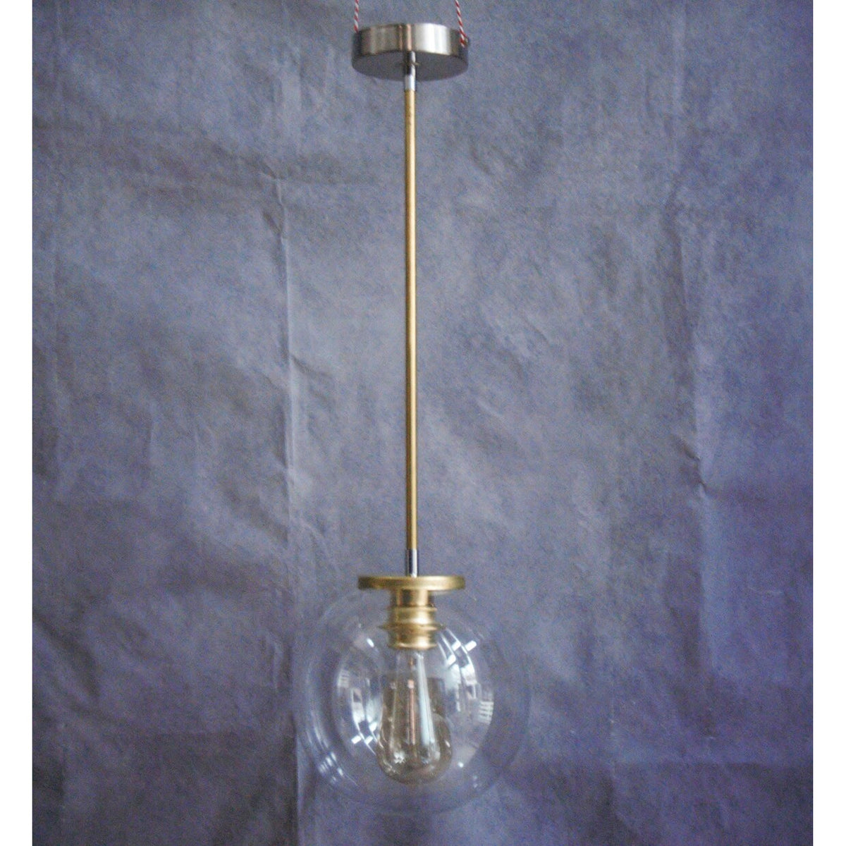 Suspension minimaliste tube en laiton et globe en verre transparent.