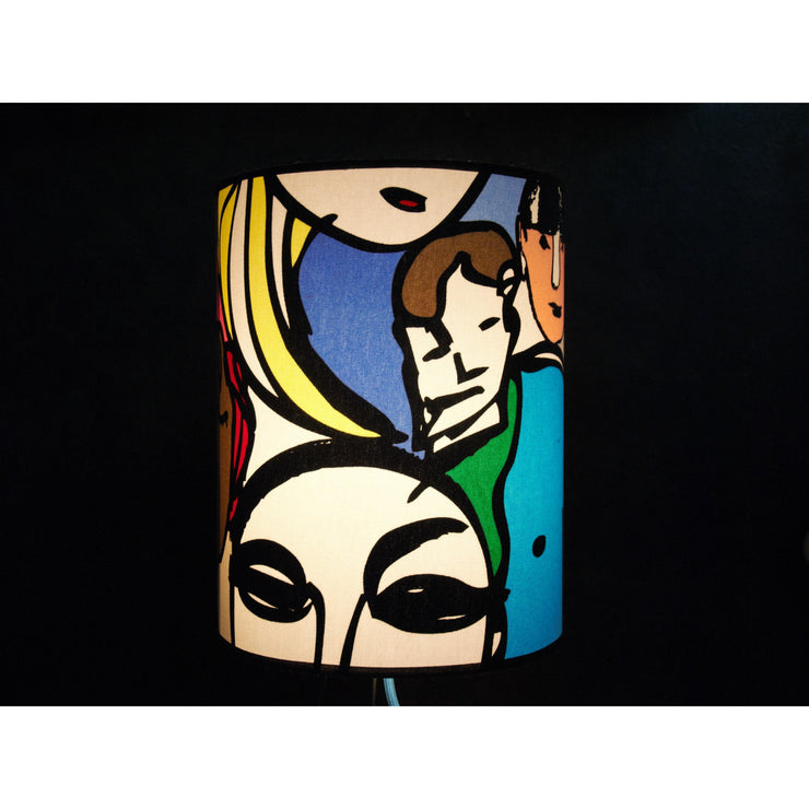 Lampe à poser abat-jour cylindrique recouverte de tissu coton personnages abstraits colorés .