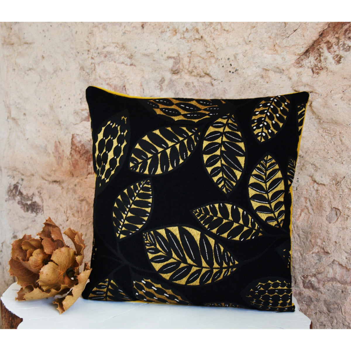 Coussin décoratif en jacquard et velours noir et jaune , feuillage ethnique de la maison Thevenon.
