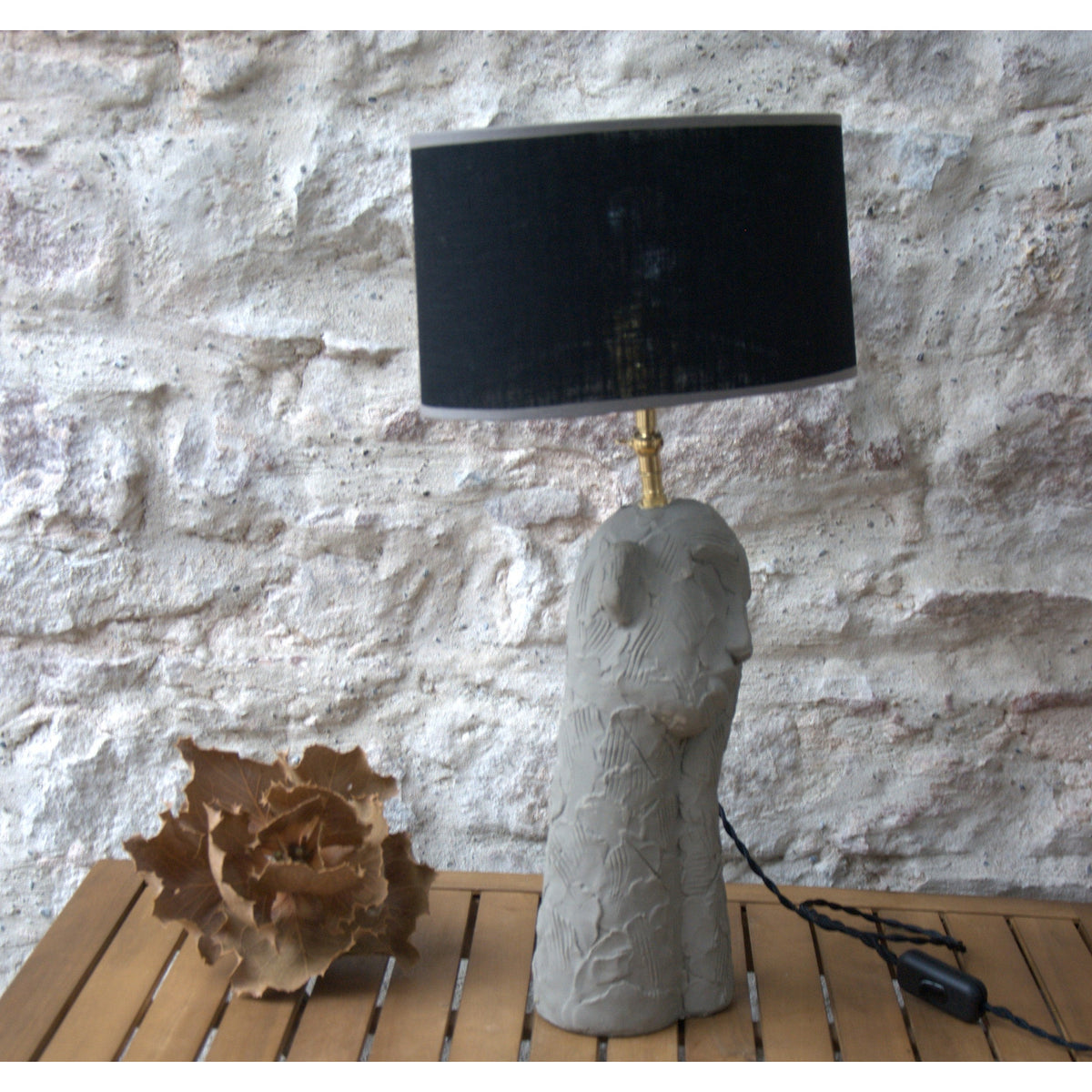 Lampe à poser sculpture ciment , abat jour ovale lin noir.