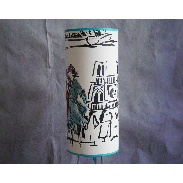 Lampe à poser abat-jour cylindrique sue trépied, papier peint Manuel Canovas.