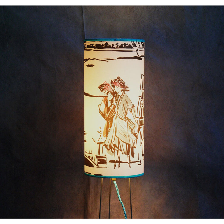 Lampe à poser abat-jour cylindrique sue trépied, papier peint Manuel Canovas.