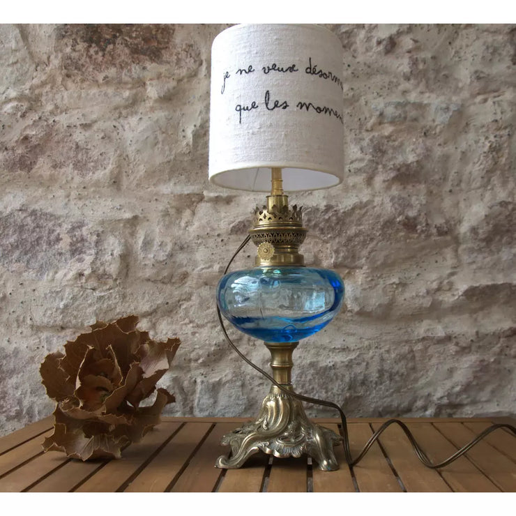 Table lamp old brass and copper oil lamp, blue glass, white linen lampshade quote Stendhal. 