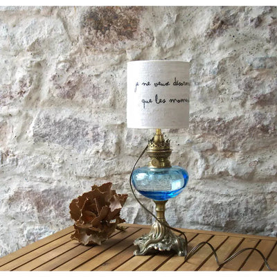 Table lamp old brass and copper oil lamp, blue glass, white linen lampshade quote Stendhal. 